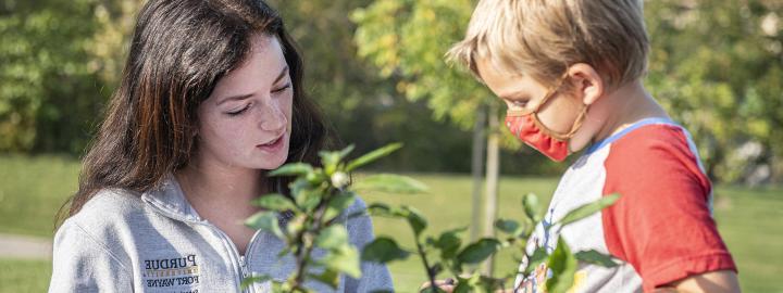 An education student with an elementary child in the Extension garden